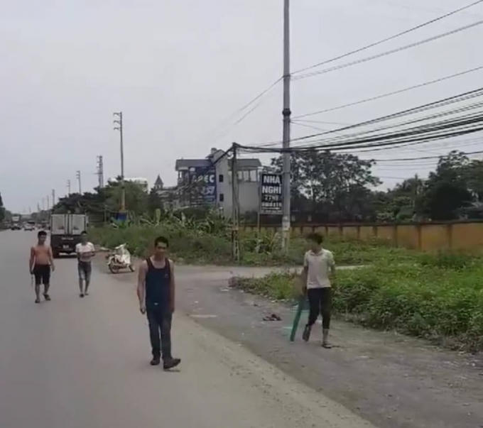 Nhóm thanh niên nghi cầm gậy chặn đầu xe để xin đểu trên địa bàn huyện Quốc Oai. Ảnh cắt từ clip.