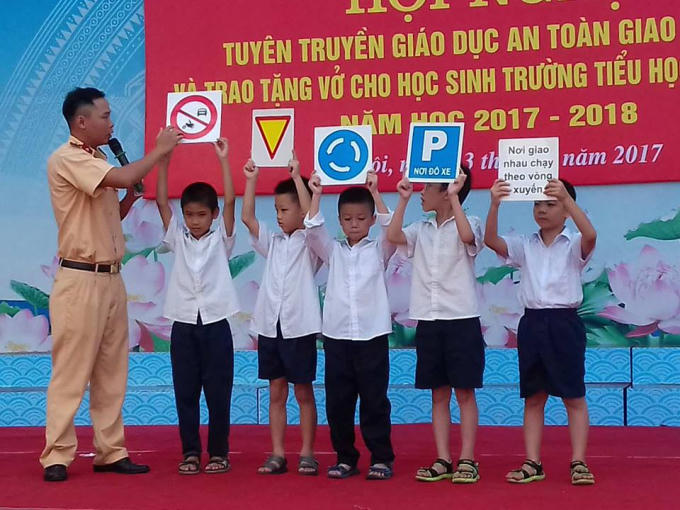 Trung úy Hoàng Hữu Đức tuyên truyền luật giao thông đến các em học sinh.