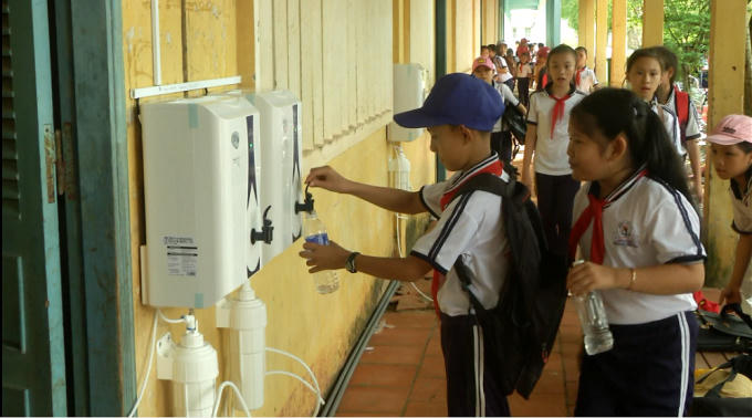 Các em học sinh vui mừng lấy nước sạch uống.