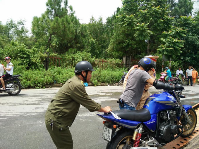 Cảm động với h&igrave;nh ảnh CSGT lội nước gi&uacute;p người d&acirc;n qua đường ngập nước