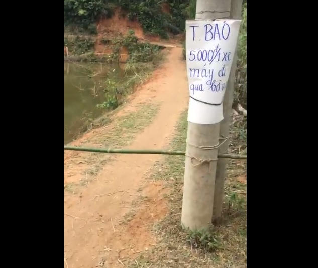 Người dân tự lập BOT "bờ ao" và tự thu phí 5.000 đồng/1 xe máy. (Ảnh cắt từ clip)
