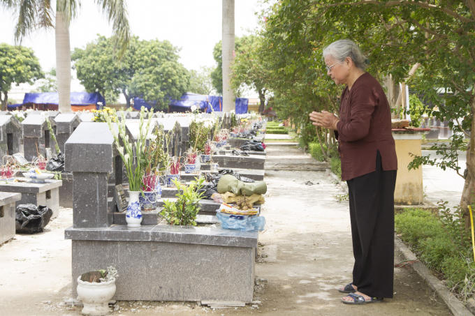 Bà Nguyễn Thị Ngọ bên phần mộ của em trai mình.