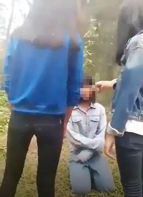 Nhóm nữ sinh bắt bạn quỳ dưới đất xin lỗi và dùng tay tát vào mặt (ảnh cắt từ clip)