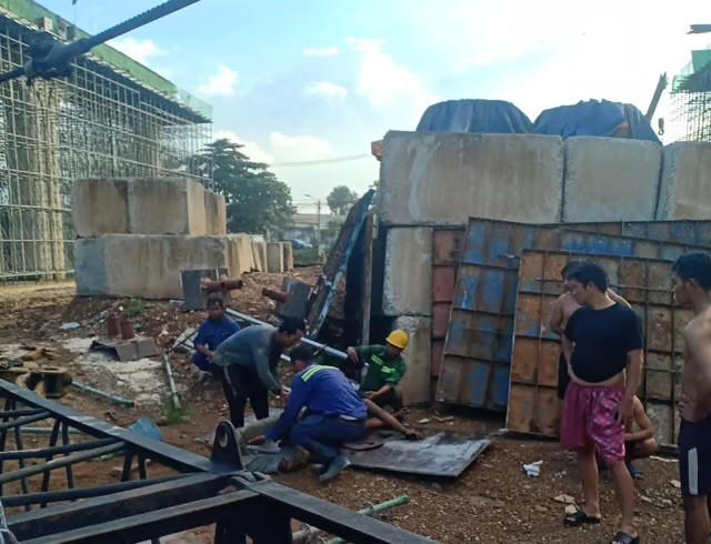 Các công nhân sơ cứu cho 2 nạn nhân bị cần cẩu sập đè.