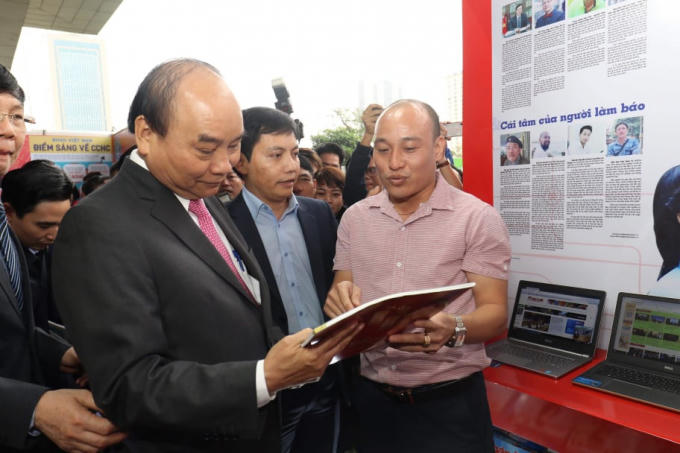 Tổng thư ký tòa soạn Pháp luật Plus Phạm Quốc Cường giới thiệu và kính tặng Thủ tướng Chính phủ Nguyễn Xuân Phúc ấn phẩm báo Xuân báo Pháp luật Việt Nam 2019. (Ảnh: Vũ Quang)