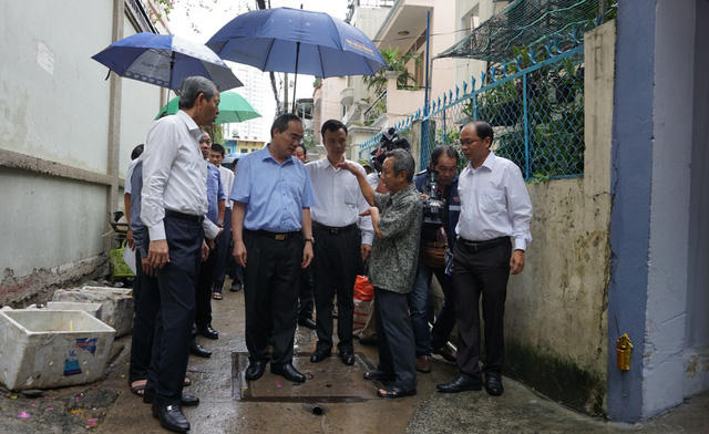 Bí thư Thành ủy TPHCM Nguyễn Thiện Nhân nghe người dân kể chuyện ngập ở đường Nguyễn Hữu Cảnh trong chuyến đi thực tế chiều 29/5.