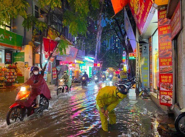 Công nhân Xí nghiệp Thoát nước số 7 khơi thông dòng chảy trên phố Triều Khúc (huyện Thanh Trì). (Ảnh: Hà Nội mới)