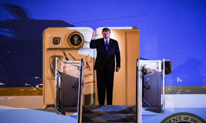 Tổng thống Trump vẫy chào trên chuyên cơ Không lực Một khi tới sân bay Nội Bài tối 26/2. Ảnh: AFP.