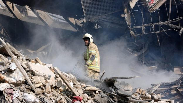 Nhân viên cứu hộ và chó nghiệp vụ tìm kiếm những người còn sống sót trong đống đổ nát. (Ảnh: EPA)