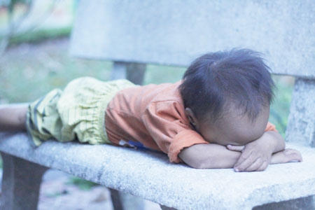 Sau bữa ăn, đứ bé nằm ra ghế đá ngủ. Dường như nó đã quá mệt mỏi.