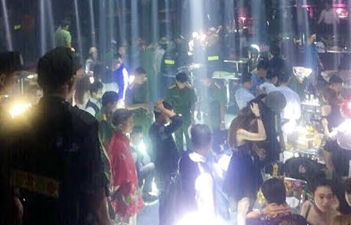 Dân chơi phải đưa tay lên đầu khi cảnh sát tìm ma túy. (Ảnh: Quốc Thắng)