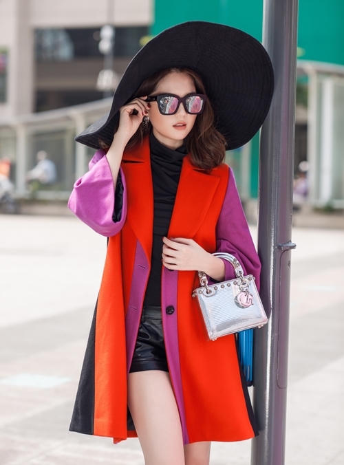Cô kết hợp hai lớp áo khoác màu rực rỡ bên ngoài trang phục tông đen và mũ rộng vành. Túi Dior dòng mới nhất được Ngọc Trinh tiết lộ có giá khoảng 110 triệu đồng.