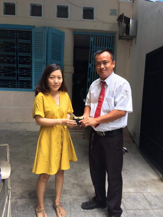 Tài xế Cường (phải) trả lại chiếc ví cho nữ du khách Hàn Quốc.