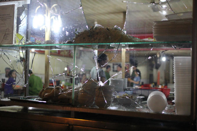 Tủ kính của quán ăn bị giang hồ đập phá.