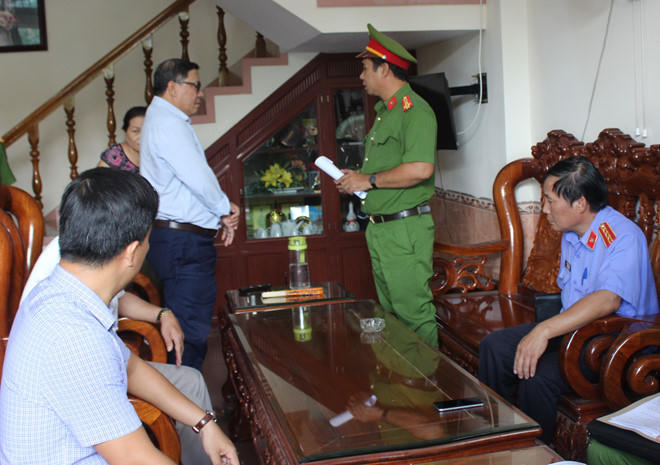 Cơ quan công an đọc lệnh bắt ông Nguyễn Tài (đứng) tại nhà riêng. Ảnh: A.Bình.