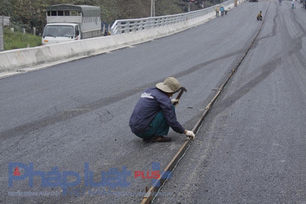 Dải phân cách đang được những công nhân kẻ trên cầu.