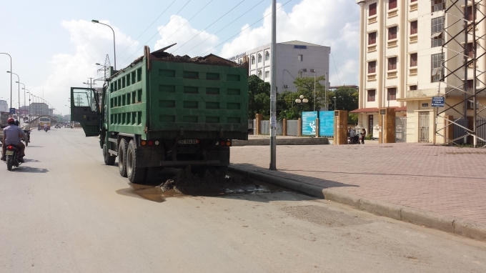 Xe tải để vương vãi vật liệu xây dựng tại chân cầu vượt Mai Dịch