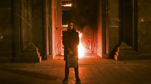 Pyotr Pavlensky tay cầm can xăng, đứng trước đống lửa tại cửa trụ sở FSB.  (Ảnh: Reuters)