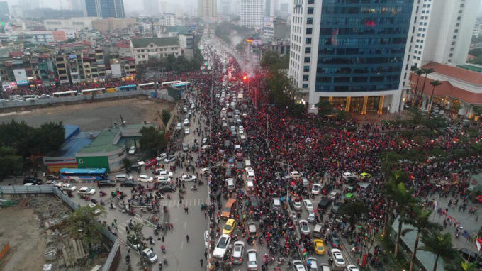 17h50, đoàn xe chở U23 Việt Nam về đến đường Kim Mã trong tiếng hô vang, cờ đỏ sao vàng và pháo sáng. (Ảnh: Quốc Trị)