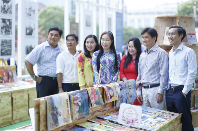 Chụp hình lưu niệm bên các gian hàng báo Xuân.