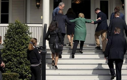 Các trợ lý dìu bà Clinton lên bậc thang. (Ảnh: CNN)