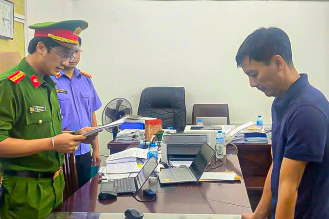 Đối tượng Trần Văn Huân (bìa phải), Giám đốc Chi nhánh Minh Bảo An Hòa Bình tại thời điểm bị bắt giữ. (Ảnh: CA Hoà Bình)