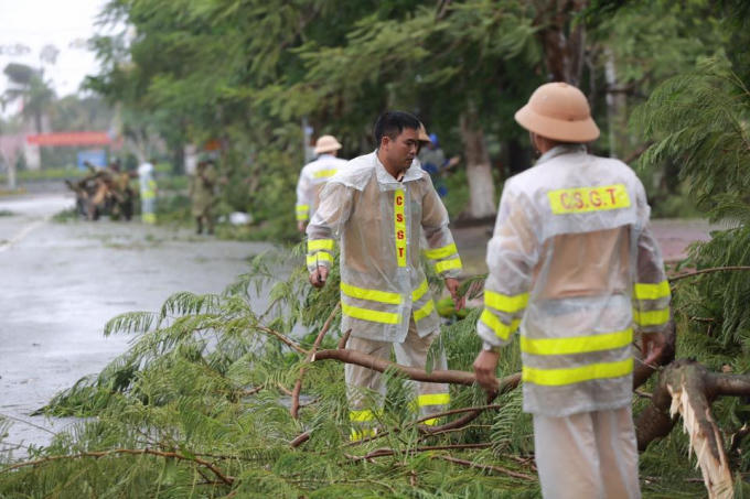 CSGT Công an thành phố Hà Tĩnh đội mưa thu gom cây cối gãy đổ.