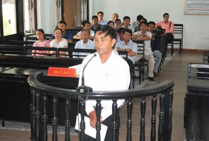 Ông Nguyễn Văn Quyền cầm nhiều hồ sơ, giấy tờ cho rằng mình vô tội trước phiên tòa.