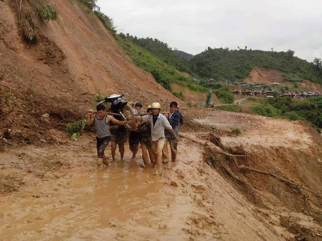 Thầy cô vác xe qua đường bùn lầy lội.