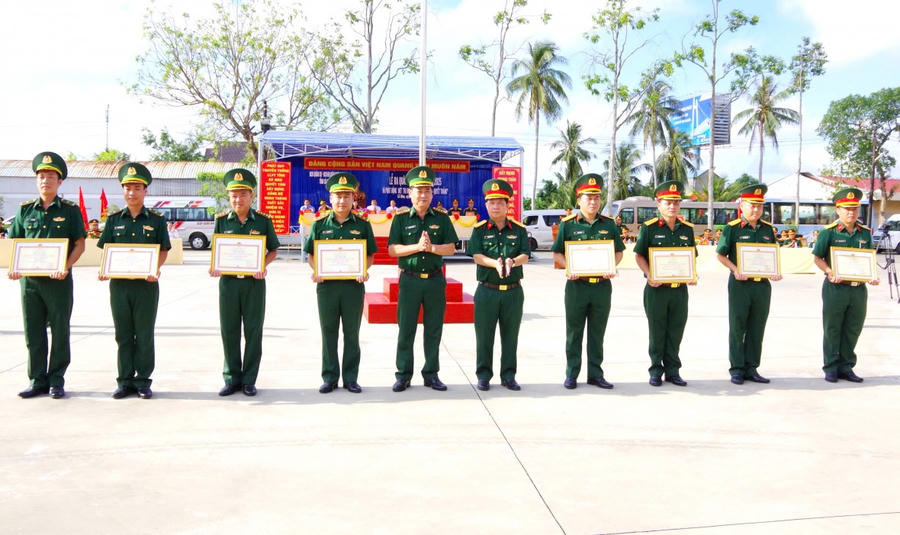 Đại tá Nguyễn Văn Hùng - Chỉ huy trưởng Bộ CHQS tỉnh Cà Mau (thứ 5 bên phải sang) và Đại tá Phạm Anh Chương - Chỉ huy trưởng BĐBP tỉnh, trao khen thưởng cho các đơn vị đạt danh hiệu đơn vị vững mạnh toàn diện, mẫu mực tiêu biểu năm 2024.