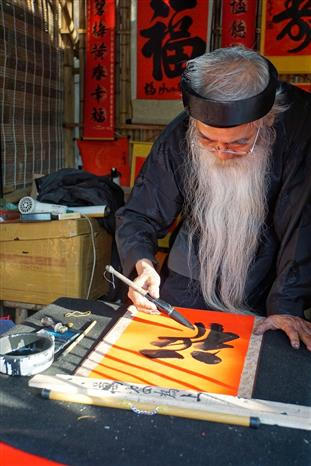 Ông đồ già đang cho chữ tại Văn Miếu-Quốc Tử Giám. Ảnh: Khánh Hòa/TTXVN phát.