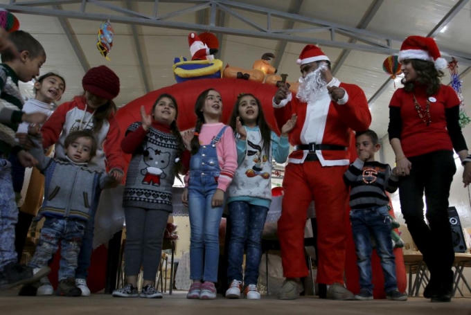Trẻ em Iraq hát những bài hát Giáng sinh cùng ông già Noel tại một khu trại gần Baghdad.  (Ảnh: Reuters)