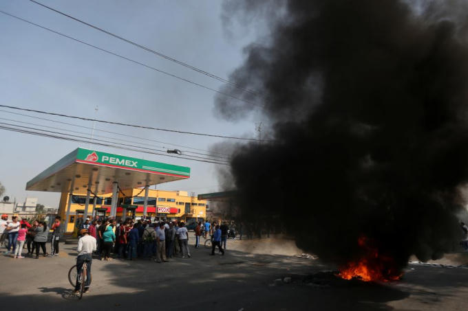 Những người biểu tình đập phá, chặn lối vào của trạm xăng thuộc quản lý của tập đoàn Pemex ở San Miguel Totolcingo. (Ảnh Reuters)
