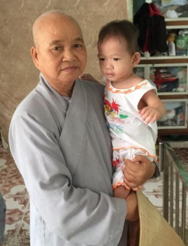 Sư cô Huệ Đức và một trẻ mổ côi.