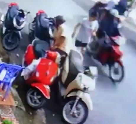 Người đàn &ocirc;ng ngang nhi&ecirc;n l&acirc;́y túi xách đang treo tr&ecirc;n xe người phụ nữ.(Ảnh cắt từ clip)