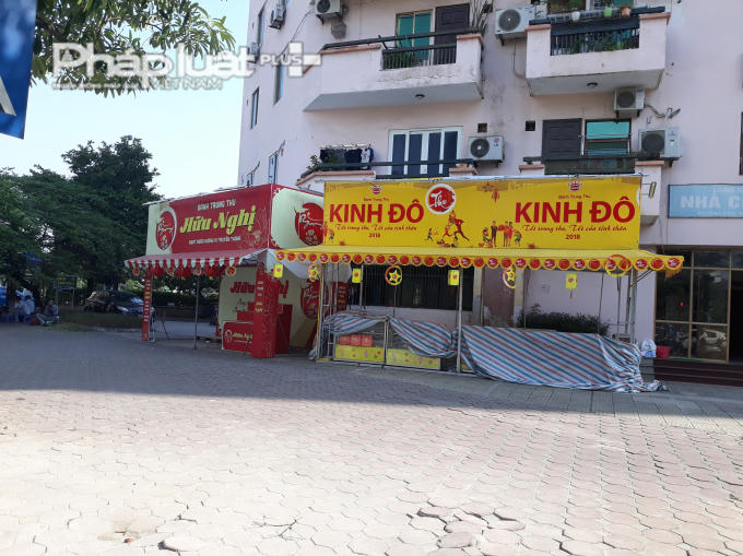 Một quầy bánh trên đường Trần Đăng Ninh (Hà Nội). Chủ quầy dùng bạt che tạm những tủ thủy tinh và hàng tồn trước khi dọn dẹp hết.