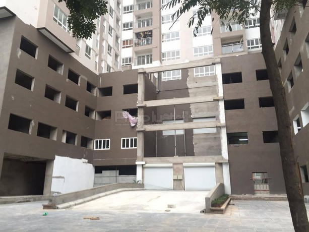 Cổng sau của toà nhà đang thi công dở dang, phía trên đã có người dân vào ở