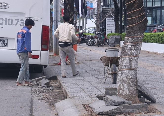 Công nhân đang tiến hành bóc dỡ các bó vỉa hè bị hư hỏng. Ảnh Nguyễn Thành