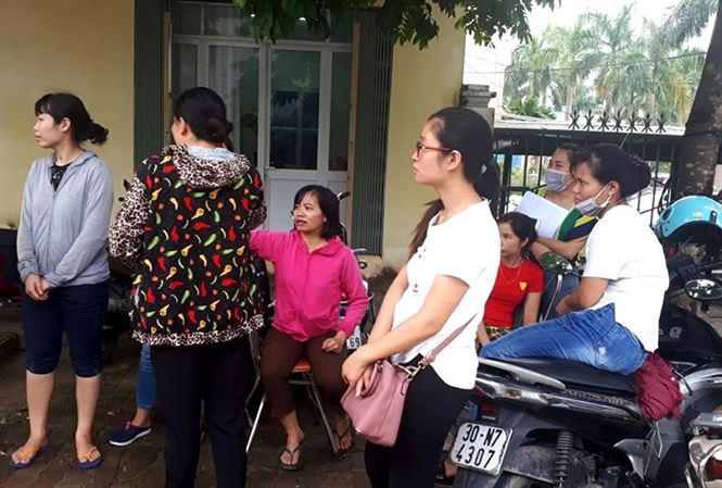 Giáo viên hợp đồng tập trung cạnh UBND huyện Thanh Oai để chờ lời giải thích thỏa đáng từ lãnh đạo huyện. Ảnh: Đình Tuệ/ Lao Động