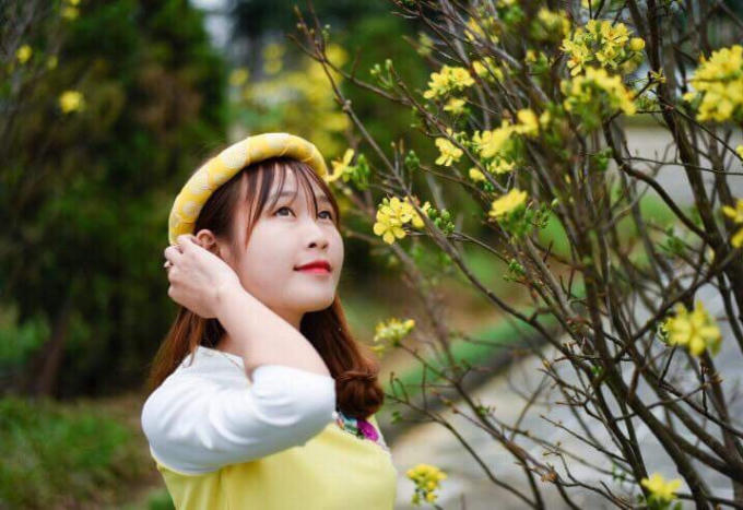 Thiếu nữ ngắm hoa Xuân đang khoe sắc.