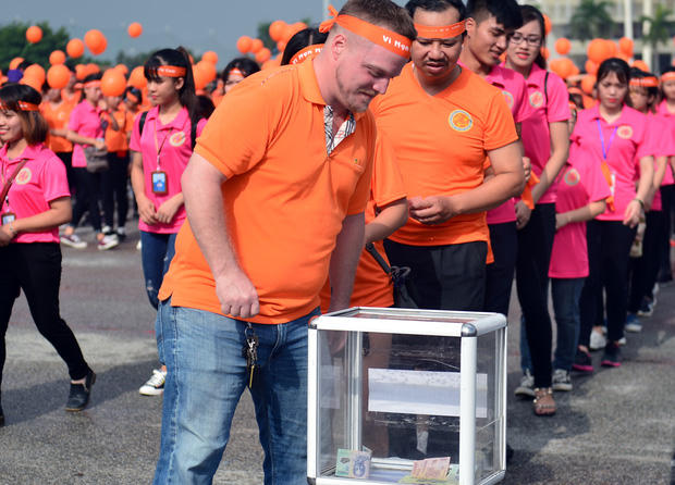 "Ông Tây móc cống" James Joseph Kendall trưởng nhóm Keep Hanoi Clean (Giữ Hà Nội sạch) hào hứng chung tay ủng hộ tại thùng quyên góp trước sân khấu.