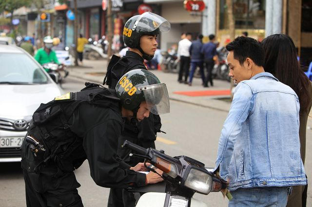 Một trường hợp vi phạm lỗi kh&ocirc;ng đội mũ bảo hiểm, bị lập bi&ecirc;n bản v&agrave; nộp phạt tại chỗ tr&ecirc;n đường Nguyễn Khang (quận Cầu Giấy).