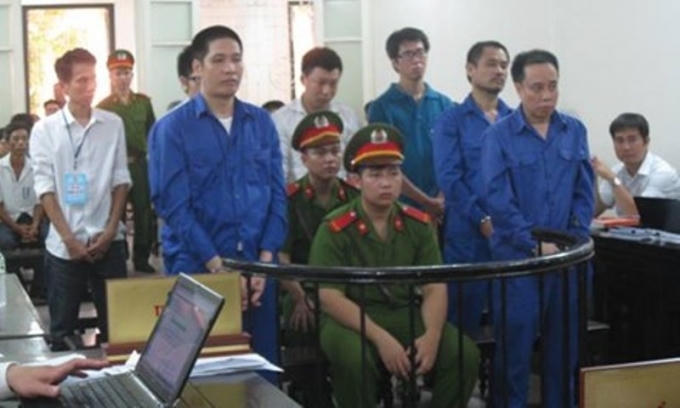 Các bị cáo đứng trước vành móng ngựa trong phiên tòa