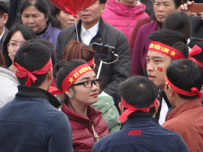 Một nhóm bạn đeo băng zôn, dán cờ vào má tham dự lễ hội.