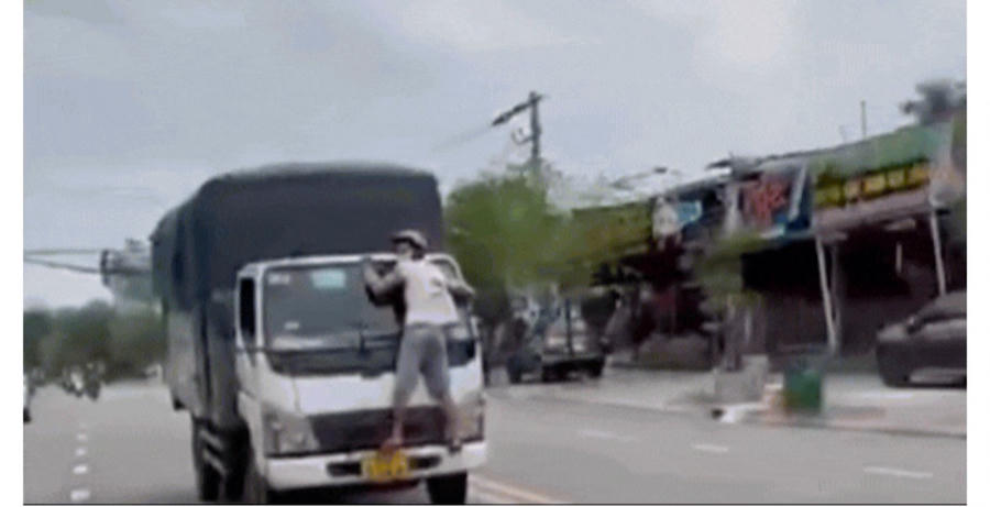 Anh Thành bám vào đầu xe tải.