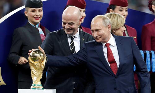 Tổng thống Nga Vladimir Putin (ngoài cùng bên phải) chạm tay vào cúp vàng World Cup trong lễ trao giải ngày 15/7. Ảnh: Reuters.