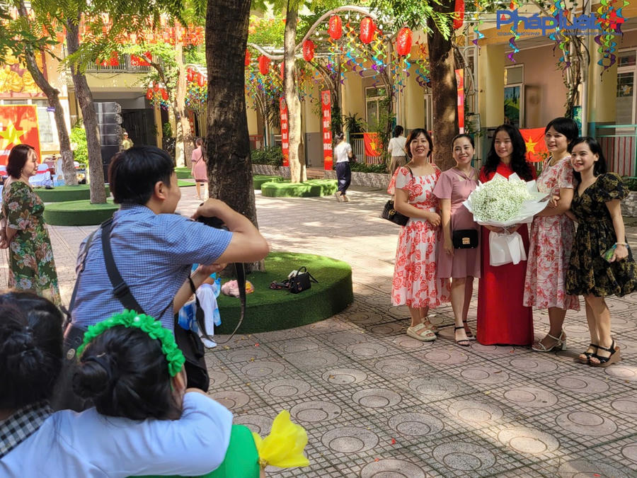 Các phụ huynh học sinh chụp ảnh lưu niệm nhân dịp khai giảng năm học mới cùng cô giáo.