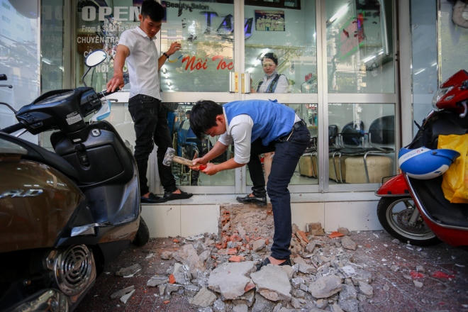 Sáng 1/3, nhân viên một tiệm tóc trên đường Lý Chính Thắng (quận 3) dùng búa đập lối lên xuống xe máy để trả lại lối đi cho người đi bộ. Trước đó ba ngày, chính quyền quận này đã thông báo đề nghị các hộ dân tự dọn dẹp, tháo dỡ những vi phạm trước khi quận kiểm tra, xử phạt.