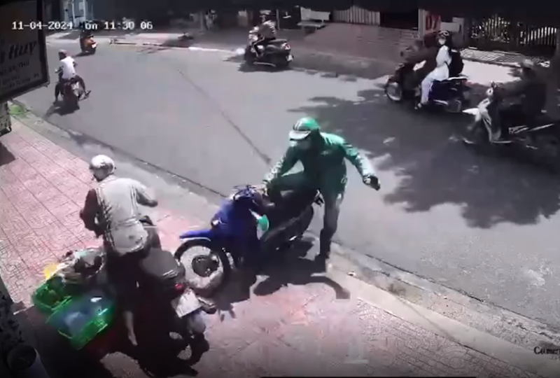 Anh Nguyễn Công Định (mặc áo xanh xe ôm công nghệ) lao xe vào đối tượng trộm xe máy (ảnh cắt từ camera).