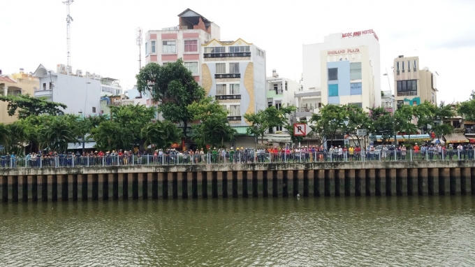 Hàng trăm người phơi nắng đứng dọc hai bờ kênh để theo dõi vụ việc.